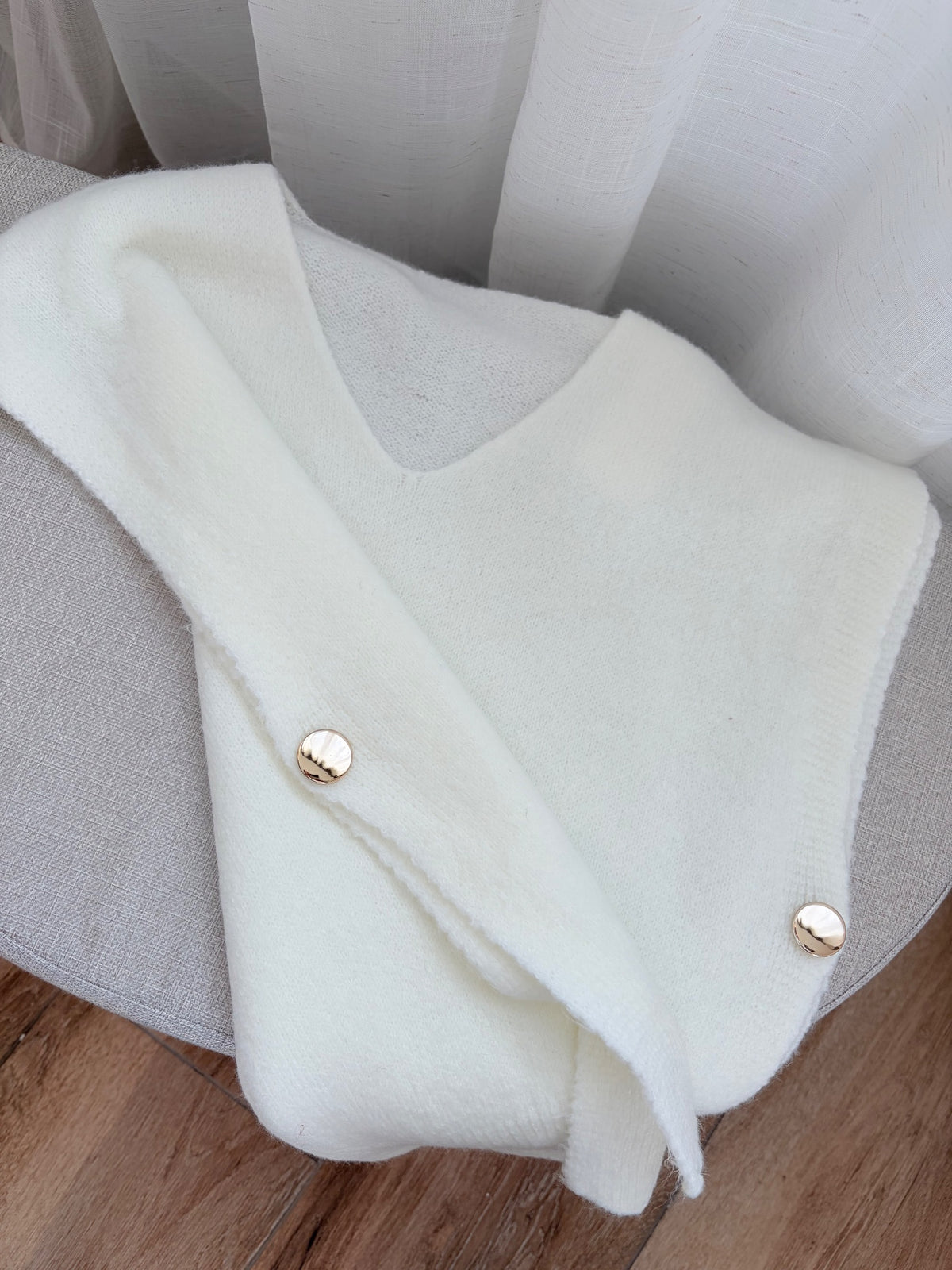 Pull sans manches blanc — détail des boutons dorés